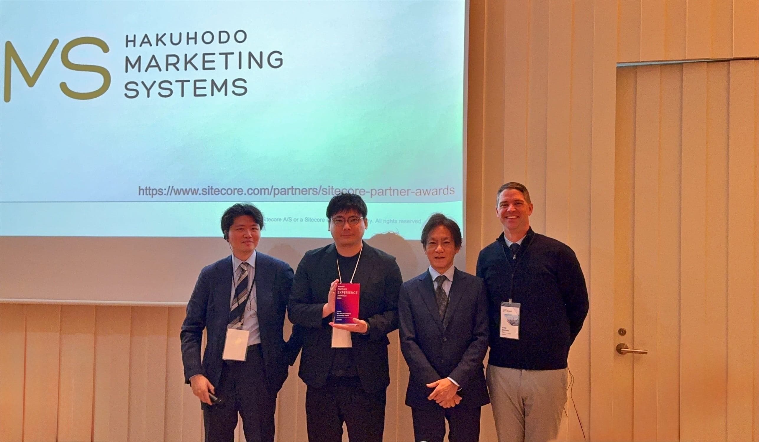 Partner Connect 2026の授賞式で、記念のトロフィーとともに並ぶ登壇者